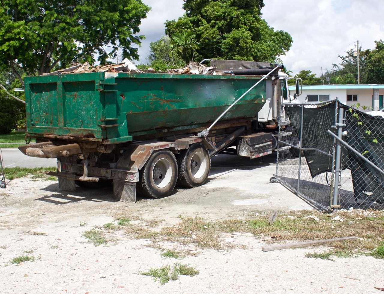 Truck Rolling off Dumpster on a Driveway